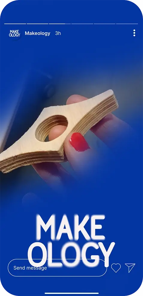 Hand with red nail polish holding a layered wooden piece with a hole in the center on blue background.